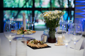 A festively served table inside the restaurant. A candle on the table. Wedding banquet.