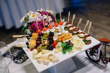 Appetizers on plates. Catering service. Wedding welcome food..Canapes (shrimp, mozzarella, sun-dried tomatoes). Welcome buffet at the event.