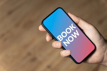 Book now - hand holding a phone