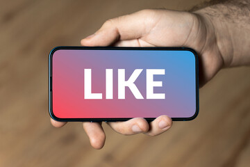 Like - hand holding a phone