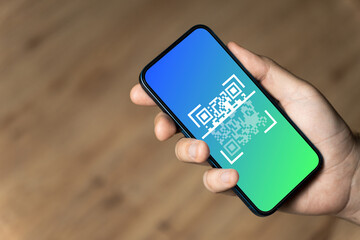 Hand holding a phone with qr code
