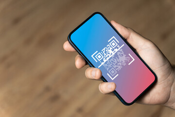 Hand holding a phone with qr code