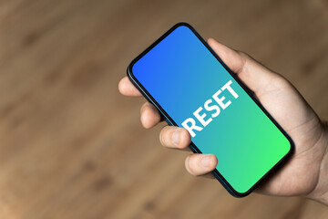 Reset - hand holding a phone