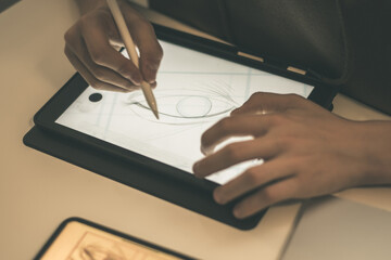 Teenager drawing with tablet and virtual pen. Millennial student doing homework with new technology devices. Young boy draw on pad at home. Male hands working with digital pencil on the touch screen. © Fabio Principe