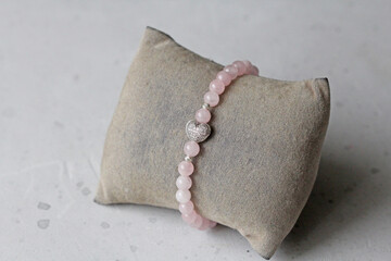 Rose quartz bracelet. A bracelet made of stones on a hand from natural stone Pink rose quartz. Bracelet made of natural stones. Handmade jewelry. Handmade bracelets on light modern background