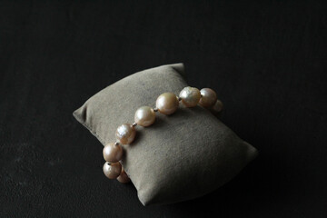 Natural Kasumi pearls bracelet. Bracelet made of stones on hand from Natural Kasumi pearls. Bracelet made of natural pearls. Handmade jewelry. Handmade pearls bracelets on black modern background