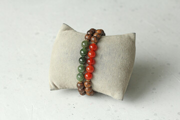 Bracelets made of natural pear wood and natural stones. Elastic bracelets. Author's jewelry handmade bracelets on a light modern concrete background. carnelian, green jade