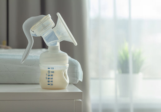 manual breast pump mith womens milk on a clother press