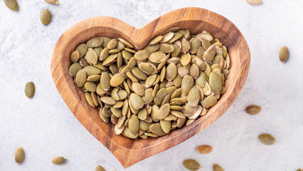Pumpkin seeds on wooden bowl. Top view
