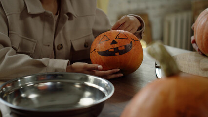 Friends are painting the halloween pumpkins and talking