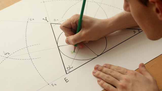 Young mathematician hands paint the green circle in triangle. Date of shooting day 27 January 2022 year, MSK time. This video was filmed in Russia.