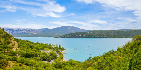 Fototapeta na wymiar Panorama of the Lake of Sainte-Croix and its surrounding mountains on a summer day in the Verdon valley, France