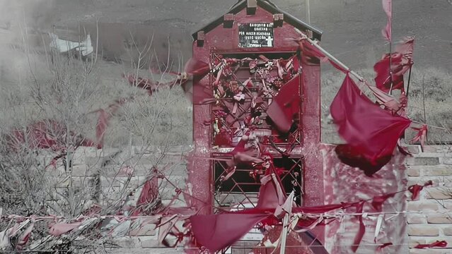 Rustic Roadside Altar to Gauchito Gil With Red Flags and Offerings in Patagonian Countryside, Argentina 