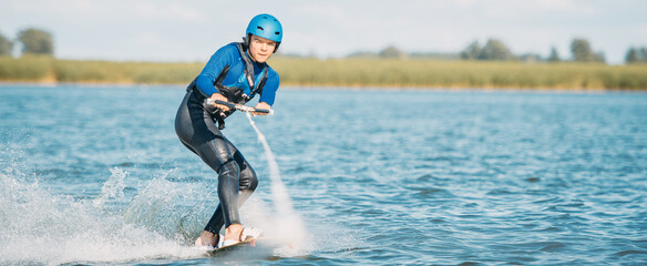 Wakeboarding narciarstwo wodne. Młody chłopak jedzie na desce za motorówką. Ekstremalny pełne adrenaliny sport