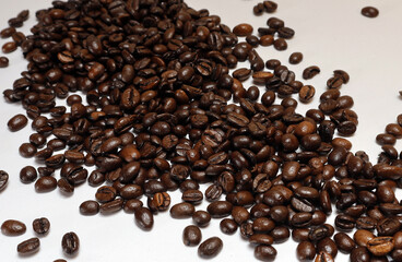 Coffee beans on a white background, close-up with free space, horizontal, selective focus.