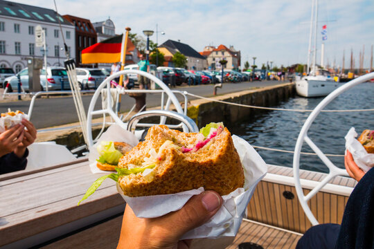 Tasty lunch on german sailing boat in marina. Fish herring sandwich sild