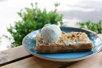 Belgian waffle with ice cream and pistachios