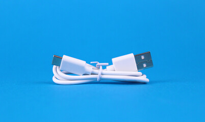 White folded usb and micro usb cable on blue background