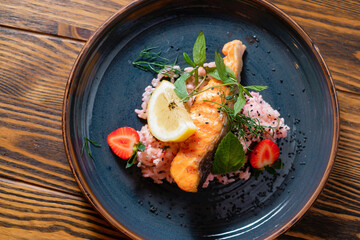 Fish with rice, lemon and strawberries. Menu design concept for a restaurant.