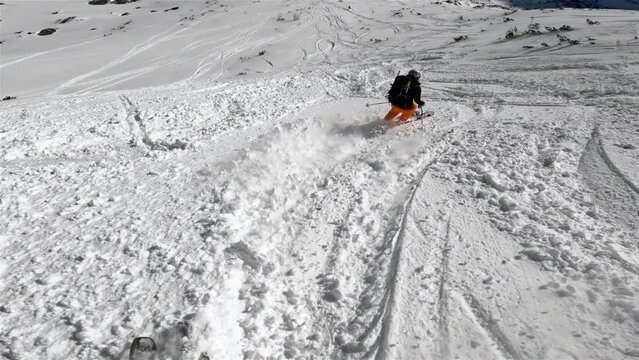 Backcountry skiing in winter alps mountains follow woman skier in free ride zone adventure