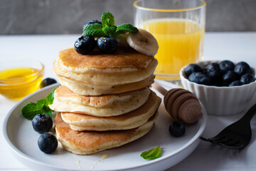 pancakes with honey and blueberries and a glass of juice