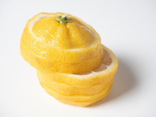 Naklejka na ściany i meble Close-up of a lemon cut into slices on a white background. isolated fruit. Sour yellow fruit full of vitamins.
