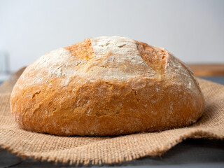 Close-up of fresh crispy round-shaped wheat bread on a dark background. Side view