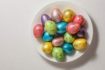easter multicolored eggs on a white platter. the concept of celebrating Easter