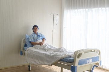 Portrait of senior cancer patient woman wearing head scarf in hospital, healthcare and medical concept