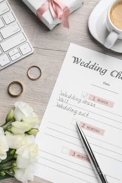 Flat lay composition with Wedding Checklist on wooden table