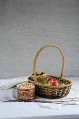 Fototapeta na wymiar Easter card. Willow branches, a basket with painted eggs and festive Easter cakes.