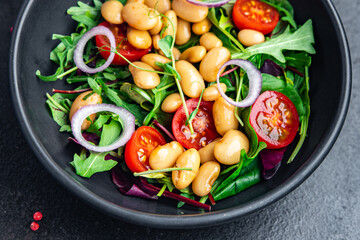 salad white beans, tomato, leaves lettuce mix petals fresh portion healthy meal food diet snack on the table copy space food background keto or paleo diet veggie vegan or vegetarian food no meat
