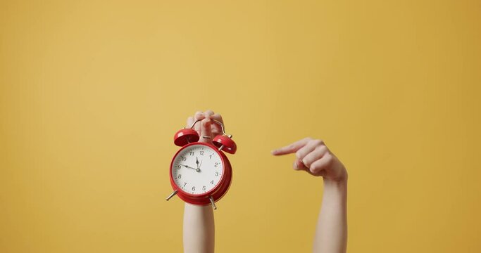 Woman gesturing with her hands with Red alarm clock on isolated on yellow background. hurry up, relive it Woman Hands gestures, and shows that he must hurry. Retro Red Clock. Alarm Time.