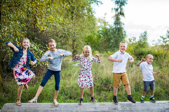 Five Cute Kids Dancing Outdoors On Log