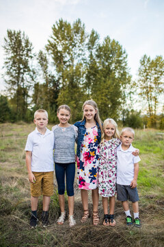 Outdoor portrait of five siblings, two boys, three girls.