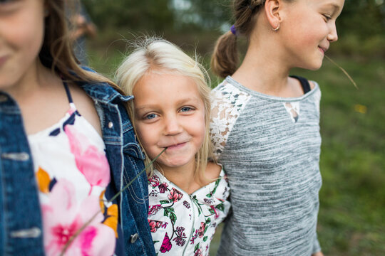Cute beautiful carefree girls outside with grass straw in mouths.