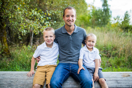 Portrait of father sitting with his two handsome young boys.