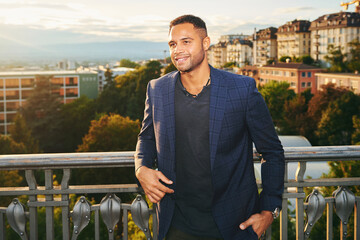 Outdoor portrait of handsome afro american man, city landscape on background