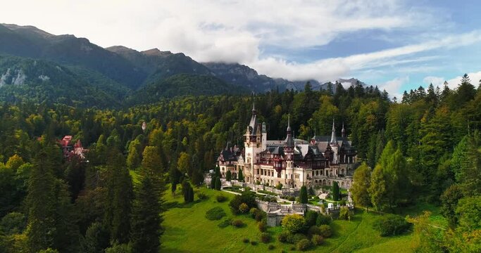 Aerial drone view of The Peles Castle in Romania. Carpathian castle surrounded by forest, summer shot, mavic 3