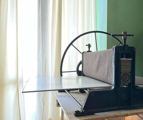 Etching press for printmaking hand made. Old ancient engraving machine. Art equipment in studio. Space for text. Linocut, woodcut, etching, print, monotype embossing, stamp. Printing step process