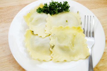Four Appetizing Large Spinach Raviolis on a White with Parsley Garnish
