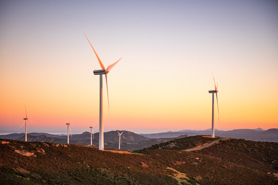 Wind turbines on a beautiful sunset sky in a mountain wind farm in Sardinia. Renewable energy concept, green energy generation. Energy industry.