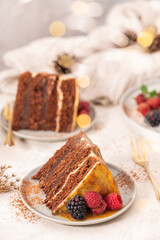 Fototapeta na wymiar Delicious semi-naked chocolate cake with caramel topping and decorated with blackberries and raspberries. Light background