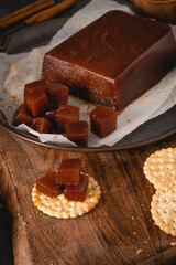 Quince cheese or marmelada is a sweet, thick jelly made of the pulp of the quince fruit. Marmalade in crackers on a kitchen counter. Dulce de membrillo in Spain
