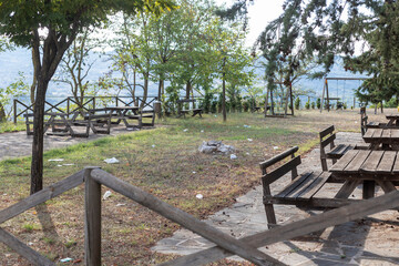 Picnic area full of man-made litter. Picnic area dirty with papers