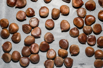 Top view of raw chestnuts on a baking sheet