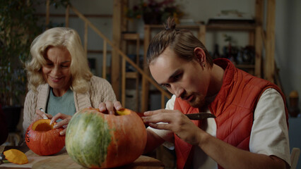 Fototapeta premium Young woman takes a slice of pumpkin from the dinner table and tastes