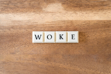 The word Woke on a wooden background.