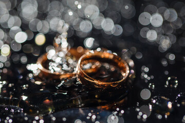 Wedding rings with water droplets,The engagement ring set.,Beautiful silver background with wedding rings and stars