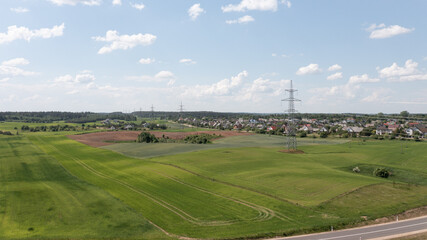 Fototapeta na wymiar Aerial View of High Voltage Electricity Tower on Green Field